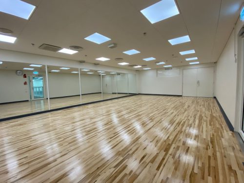 An empty hardwood floor room with mirrors